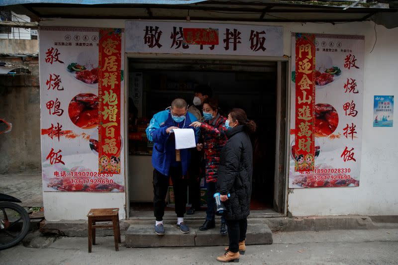 Members of a neighbourhood committee register a local and ask about his travel history in Jiujiang