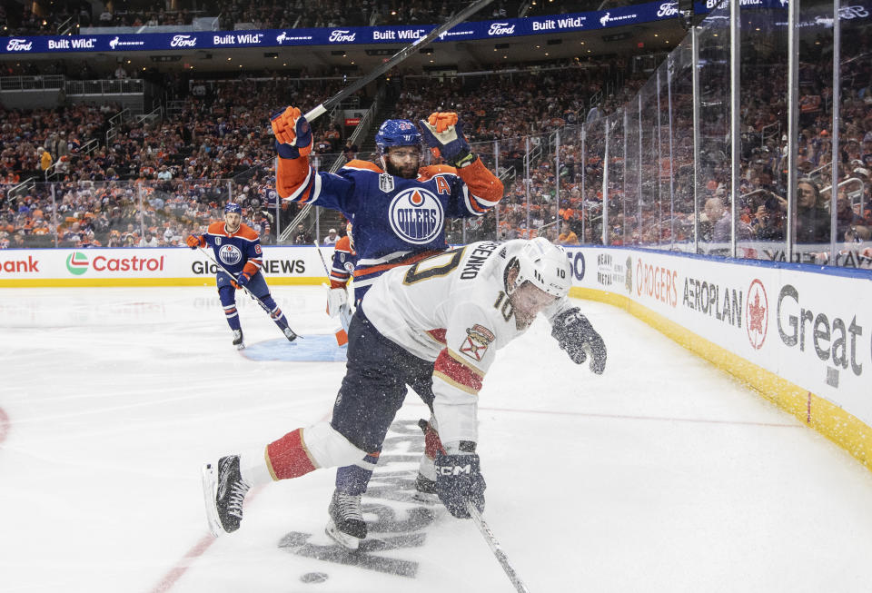 Florida Panthers' Vladimir Tarasenko (10) is checked by Edmonton Oilers' Darnell Nurse (25) during the third period of Game 6 of the NHL hockey Stanley Cup Final, Friday, June 21, 2024, in Edmonton, Alberta. The Oilers won 5-1 to tie the series. (Jason Franson/The Canadian Press via AP)