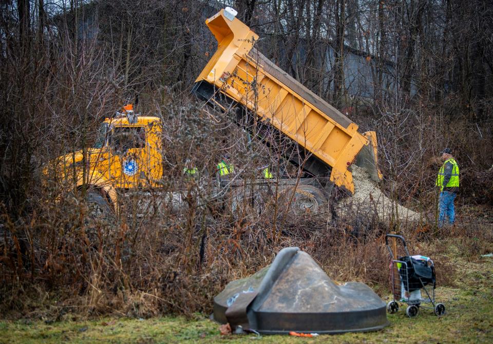 Members of Bloomington's street and public works departments put down gravel to help with the eviction of a homeless persons' encampment behind Wheeler Mission on Thursday, Jan. 25, 2024.