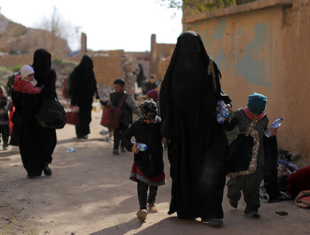 Families of Islamic state fighters walk as they surrendered in the village of Baghouz, Deir Al Zor province, Syria March 12, 2019. REUTERS/Rodi Said