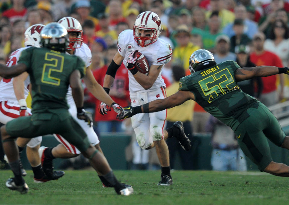 Jan 2, 2012; Pasadena, CA, USA; Wisconsin Badgers wide receiver Jared Abbrederis (4) avoids a tackle by Oregon Ducks linebacker Dewitt Stuckey (52) in the 2012 Rose Bowl game at the Rose Bowl. Mandatory Credit: Kelvin Kuo-USA TODAY Sports