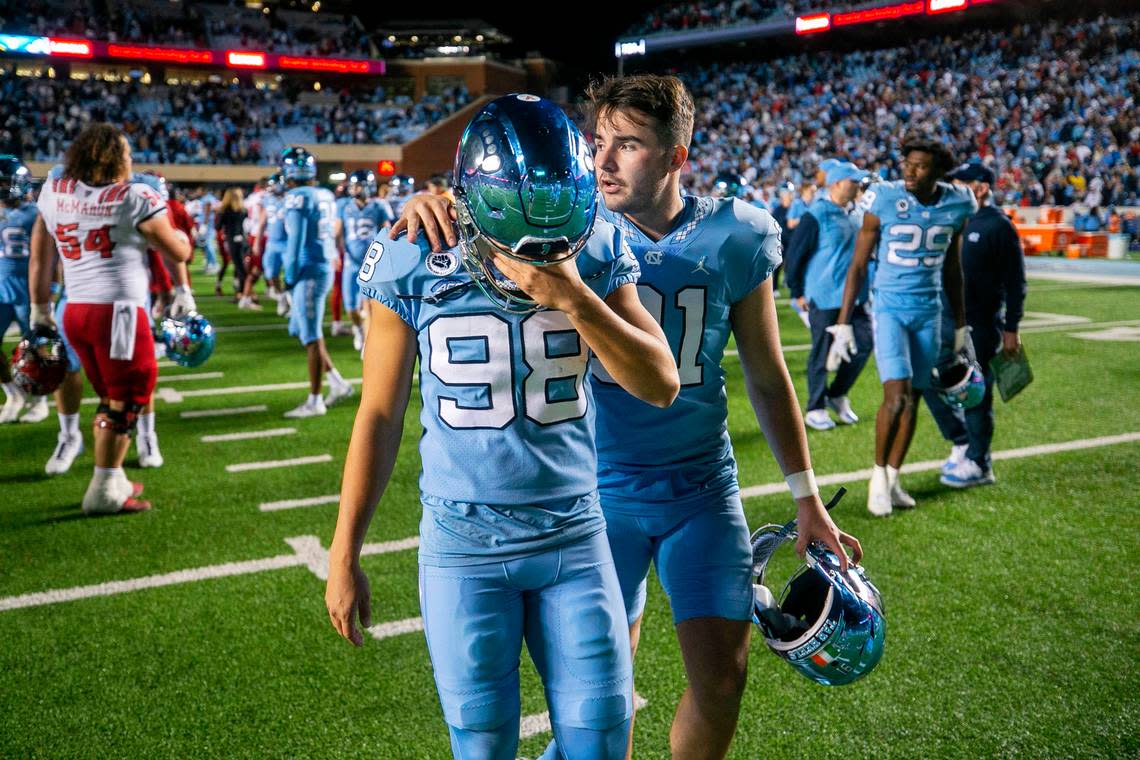 North Carolina punter Ben Kiernan (91) consoles kicker Noah Burnette (98) after Burnette missed a 35-yard field goal attempt in overtime to give N.C. State a 30-27 victory on Friday, November 25, 2022 at Kenan Stadium in Chapel Hill, N.C. Robert Willett/rwillett@newsobserver.com