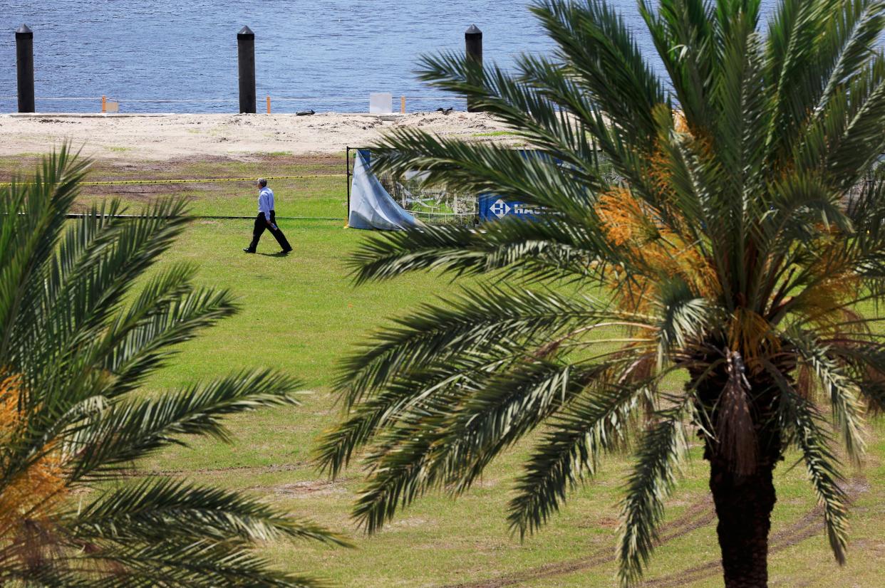 A man passes a fence line for construction on April 17 near the former site of The Jacksonville Landing. The city plans to turn the site into a "world-class" park called Riverfront Plaza. Construction started this year by rerouting a portion of Independent Drive and work is happening now on the bulkhead along the St. Johns River.