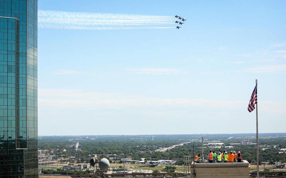 Construction workers watch from the top of a downtown building as the Navy’s Blue Angels fly over Fort Worth to honor COVID-19 first responders on Wednesday, May 6, 2020.