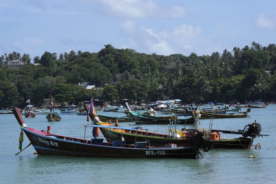 Empty tourist boats sit at anchor at Rawai Beach on Phuket, southern Thailand, Monday, June 28, 2021. Thailand's government will begin the "Phuket Sandbox" scheme to bring the tourists back to Phuket starting July 1. Even though coronavirus numbers are again rising around the rest of Thailand and prompting new lockdown measures, officials say there's too much at stake not to forge ahead with the plan to reopen the island to fully-vaccinated travelers. (AP Photo/Sakchai Lalit)