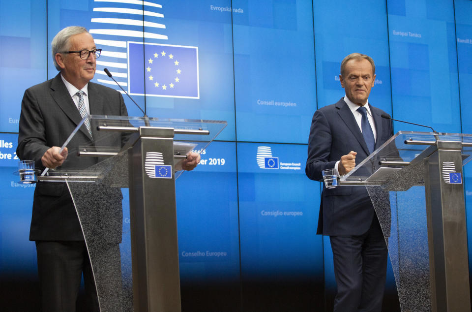 European Commission President Jean-Claude Juncker, left, and European Council President Donald Tusk participate in a media conference at an EU summit in Brussels, Friday, Oct. 18, 2019. After agreeing on terms for a new Brexit deal, European Union leaders are meeting again to discuss other thorny issues including the bloc's budget and climate change. (AP Photo/Virginia Mayo)