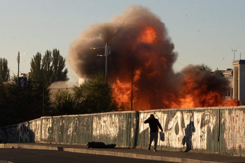 A man falls on the ground following a drone attack in Kyiv on October 17, 2022, amid the Russian invasion of Ukraine.