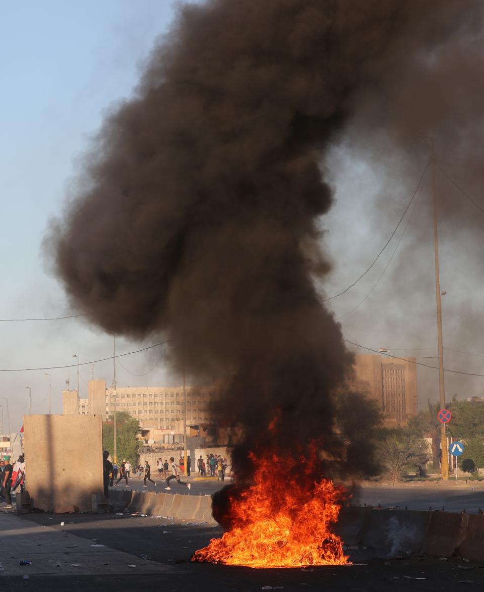 Anti-government protesters set fires and close a street during a demonstration in Baghdad, Iraq, Friday, Oct. 4, 2019. Security forces opened fire directly at hundreds of anti-government demonstrators in central Baghdad, killing several protesters and injuring dozens, hours after Iraq's top Shiite cleric warned both sides to end four days of violence "before it's too late." (AP Photo/Khalid Mohammed)