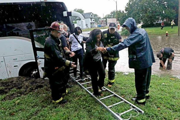 PHOTO: Firefighters with Engine House No. 10 assist a group of adults and students off a bus that got stuck in rising flood waters in St. Louis, Ky., July 28, 2022. (Laurie Skrivan/St. Louis Post-Dispatch via AP)