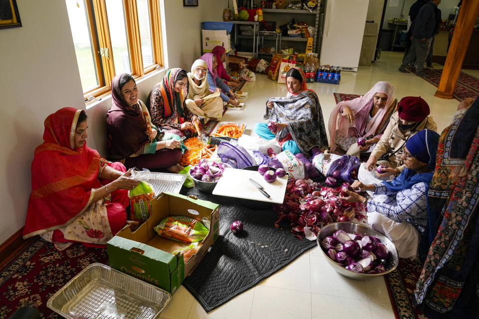 Members of the Sikh Satsang of Indianapolis prepare a communal meal in their Gurdwara building in Indianapolis, Saturday, April 17, 2021 where the Sikh Coalition held a meeting to formulate the groups response to the shooting at a FedEx facility in Indianapolis that claimed the lives of four members of the Sikh community. A gunman killed eight people and wounded several others before taking his own life in a late-night attack at a FedEx facility near the Indianapolis airport. (AP Photo/Michael Conroy)