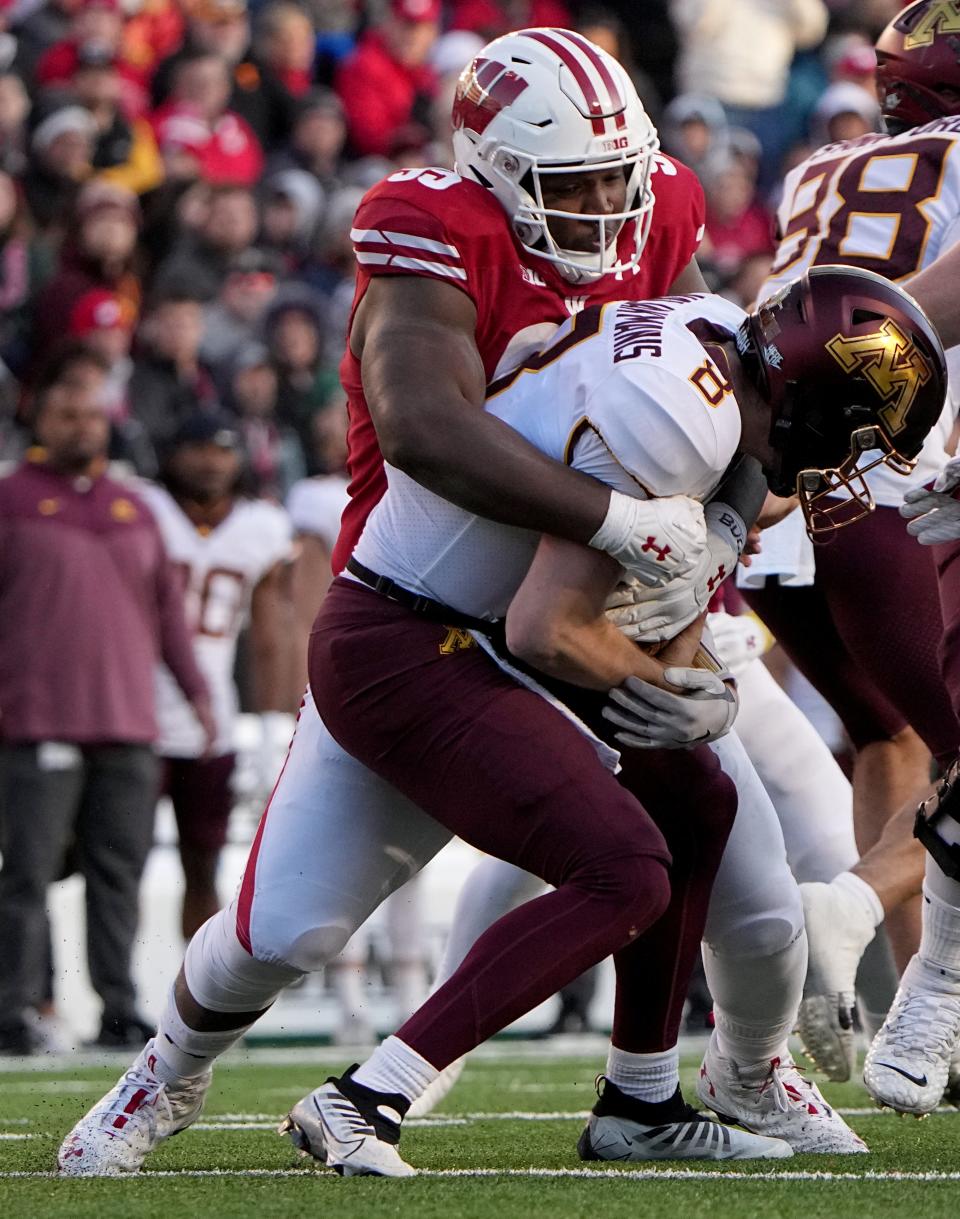 Wisconsin nose tackle Keeanu Benton sacks Minnesota quarterback Athan Kaliakmanis.