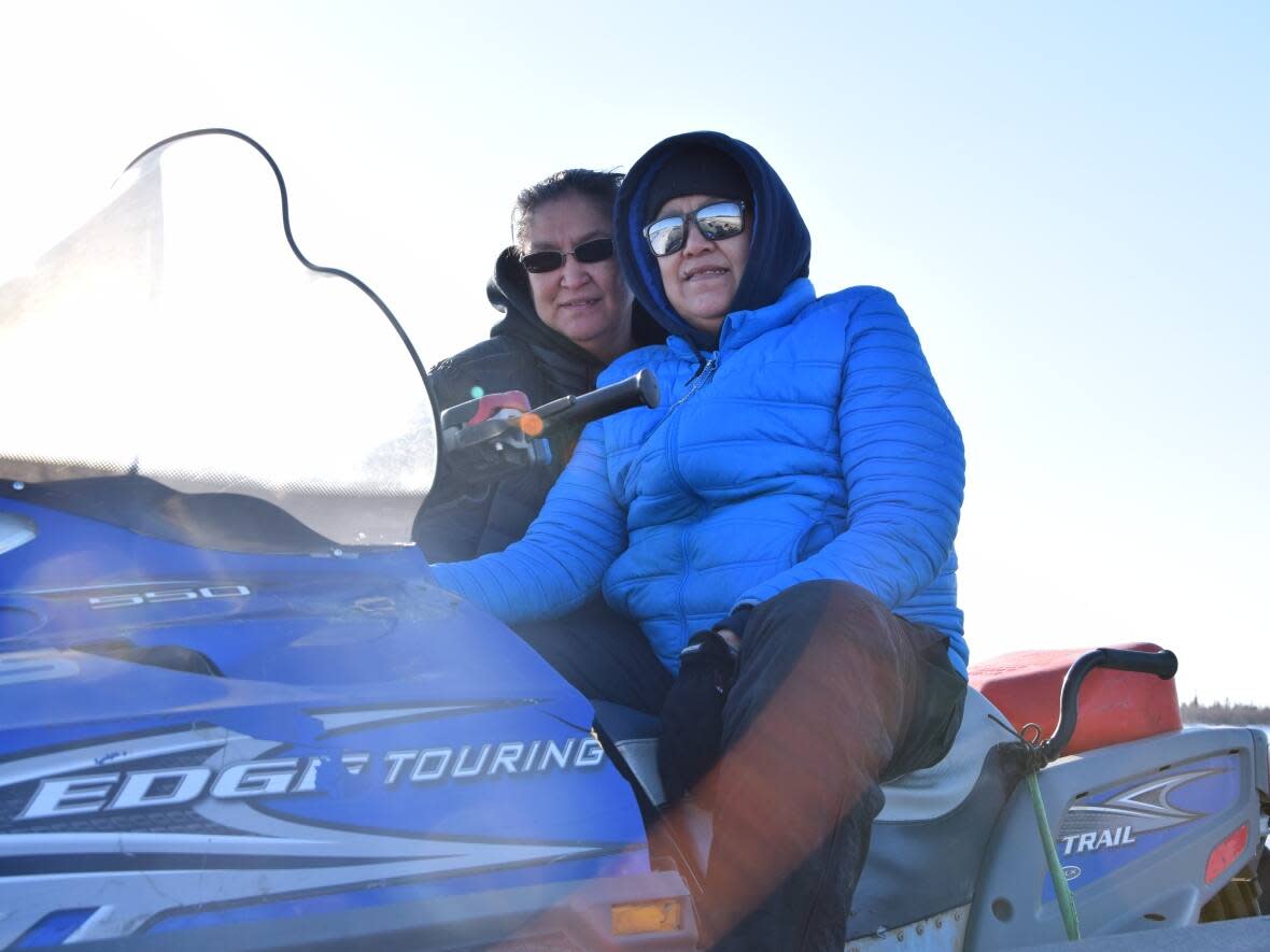 Sisters Bernice and Tina Joe of Inuvik enjoying their favourite event at the Inuvik Muskrat Jamboree: the Men’s Open Class 100 Mile Track Race. The event returned this past weekend after a two-year pandemic break. (Karli Zschogner/CBC - image credit)