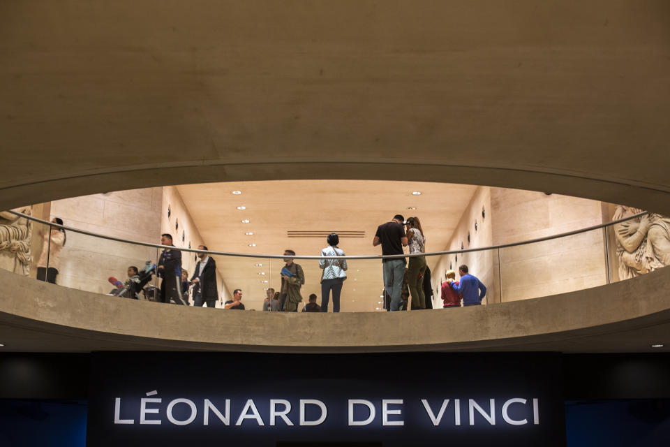 Visitors stand next to Leonardo da Vinci exhibition at the Louvre museum Sunday, Oct. 20, 2019 in Paris. A unique group of artworks is displayed at the Louvre museum in addition to its collection of paintings and drawings by the Italian master. The exhibition opens to the public on Oct.24, 2019. (AP Photo/Rafael Yaghobzadeh)