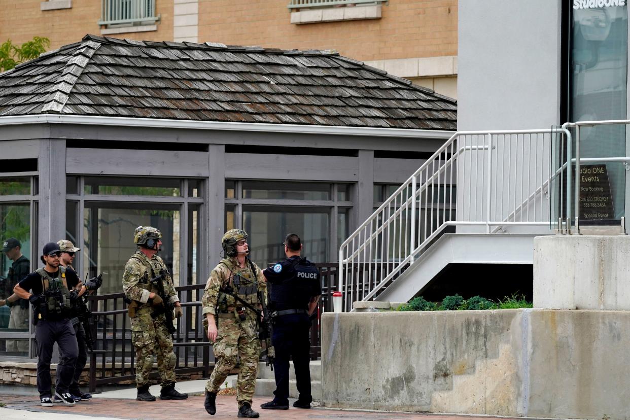 Law enforcement search in downtown Highland Park, a Chicago suburb, after a mass shooting at the Highland Park Fourth of July parade, Monday, July 4, 2022. 