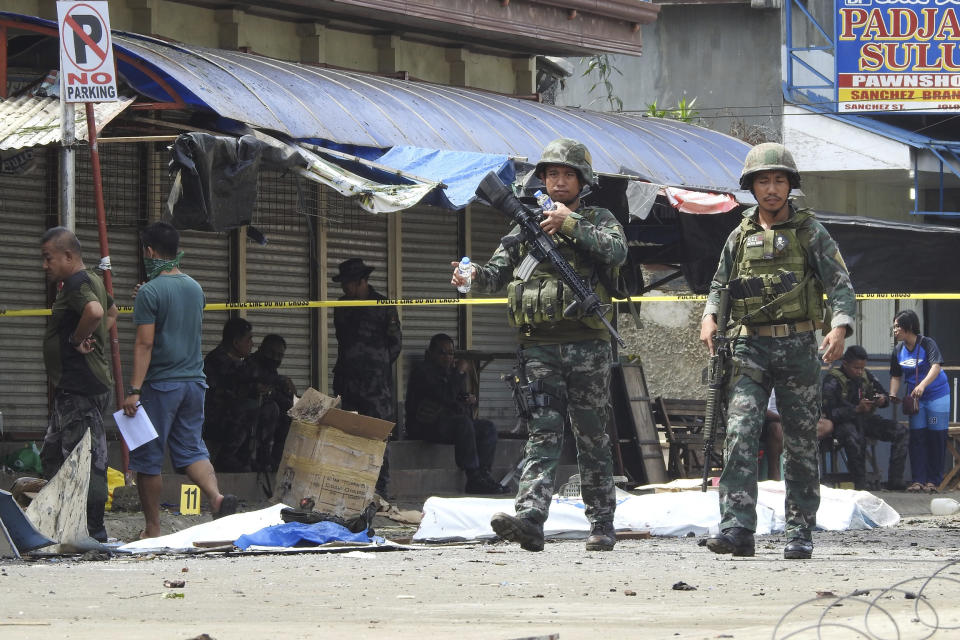 Soldiers attend the scene after two bombs exploded outside a Roman Catholic cathedral in Jolo, the capital of Sulu province in southern Philippines, Sunday, Jan. 27, 2019. Two bombs minutes apart tore through a Roman Catholic cathedral on a southern Philippine island where Muslim militants are active, killing at least 20 people and wounding more than 80 others during a Sunday Mass, officials said. (AP Photo/Nickee Butlangan)