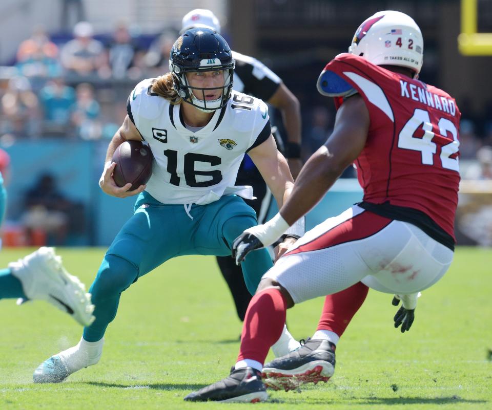 Jacksonville Jaguars quarterback Trevor Lawrence (16) tries to elude Arizona Cardinals linebacker Devon Kennard (42) at TIAA Bank Field in Jacksonville on Sept. 26, 2021.