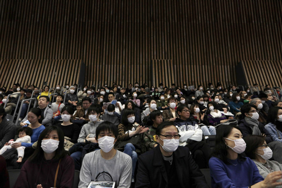 Espectadores con máscaras escuchan un discurso durante la ceremonia de apertura de la arena Ariake, sede del voléibol de los Juegos Olímpicos de Tokio 2020, el domingo 2 de febrero de 2020. (AP Foto/Jae C. Hong)