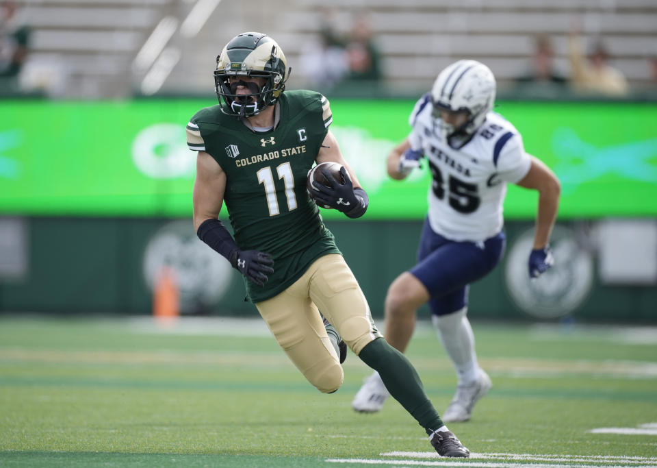 Colorado State defensive back Henry Blackburn, front, runs after intercepting a pass intended for Nevada tight end Cameron Zeidler in the first half of an NCAA college football game Saturday, Nov. 18, 2023, in Fort Collins, Colo. (AP Photo/David Zalubowski)