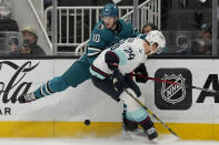 San Jose Sharks center Klim Kostin (10) looks for the puck behind Seattle Kraken defenseman Jamie Oleksiak (24) during the first period of an NHL hockey game in San Jose, Calif., Monday, April 1, 2024. (AP Photo/Jeff Chiu)