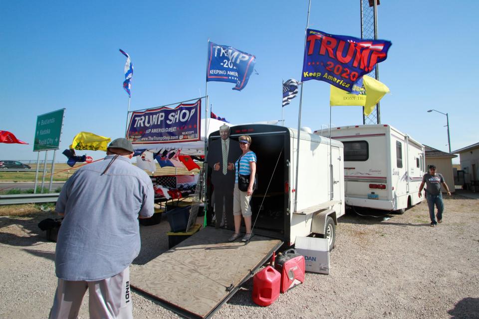 Motorcycle riders on their way to the Sturgis Motorcycle Rally stop at a stand selling Trump displays in Wall, S.D., on Saturday, Aug. 8, 2020. The group has taken advantage of recent motorcycle rallies, which have been some of the largest mass gatherings in the country, to make direct appeals to register to vote. While the group has gained a significant online following for its shows of bravado, it remains to be seen if they can get ballot boxes filled with bikers, many who hail from the suburbs. (AP Photo/Stephen Groves)