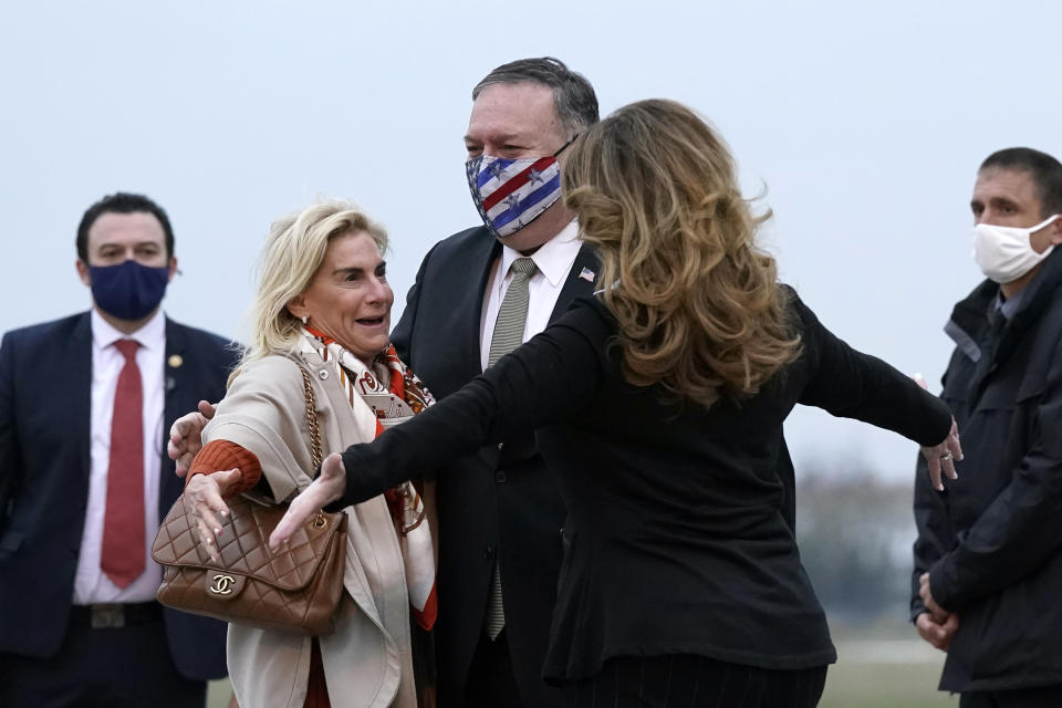 U.S. Secretary of State Mike Pompeo, center, and his wife Susan, right, embrace U.S. Ambassador to France Jamie McCourt, left, after stepping off a plane at Paris Le Bourget Airport, Saturday, Nov. 14, 2020, in Le Bourget, France. Pompeo is beginning a 10-day trip to Europe and the Middle East. (AP Photo/Patrick Semansky, Pool)
