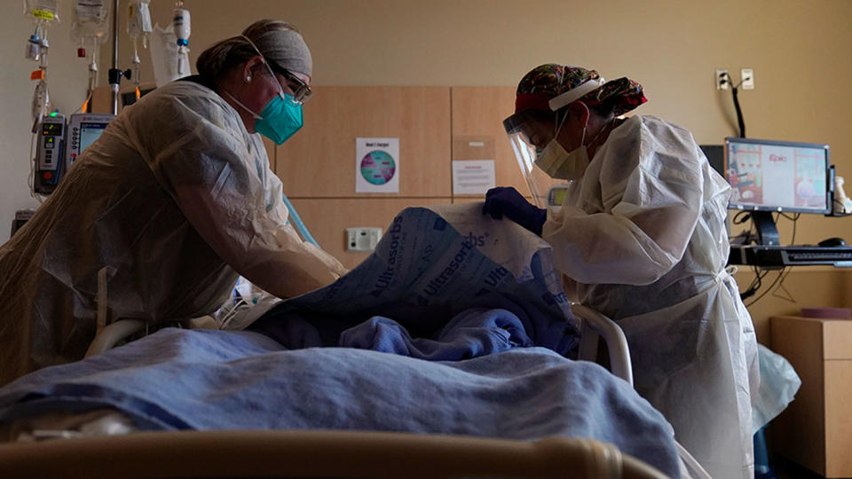 Registered nurses Robin Gooding, left, and Johanna Ortiz treat a COVID-19 patient at Providence Holy Cross Medical Center in the Mission Hills section of Los Angeles