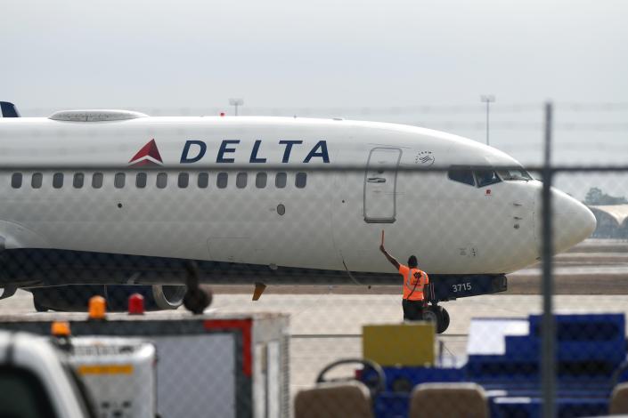 A ground crew member guides a Delta passenger jet into the terminal at the Destin-Fort Walton Beach Airport.  As of October of this year, the airport has seen a total of 1.76 million passengers, breaking the previous record of 1.67 million for all of 2019.