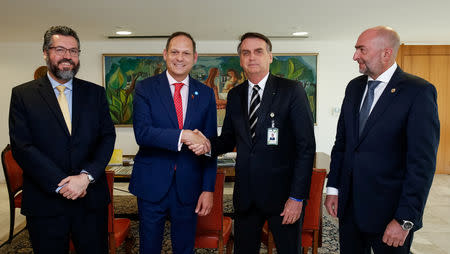 Brazil's President Jair Bolsonaro (2nd R) shakes hands with President of the Supreme Court of Justice of Venezuela in exile Miguel Angel Martin, accompanied by Foreign Minister Ernesto Araujo (L) and the representative of the Organization of American States Gustavo Cinosi (R), during a meeting at the Planalto Palace, in Brasilia, Brazil, January 17, 2019. Alan Santos/Presidency Brazil/Handout via Reuters