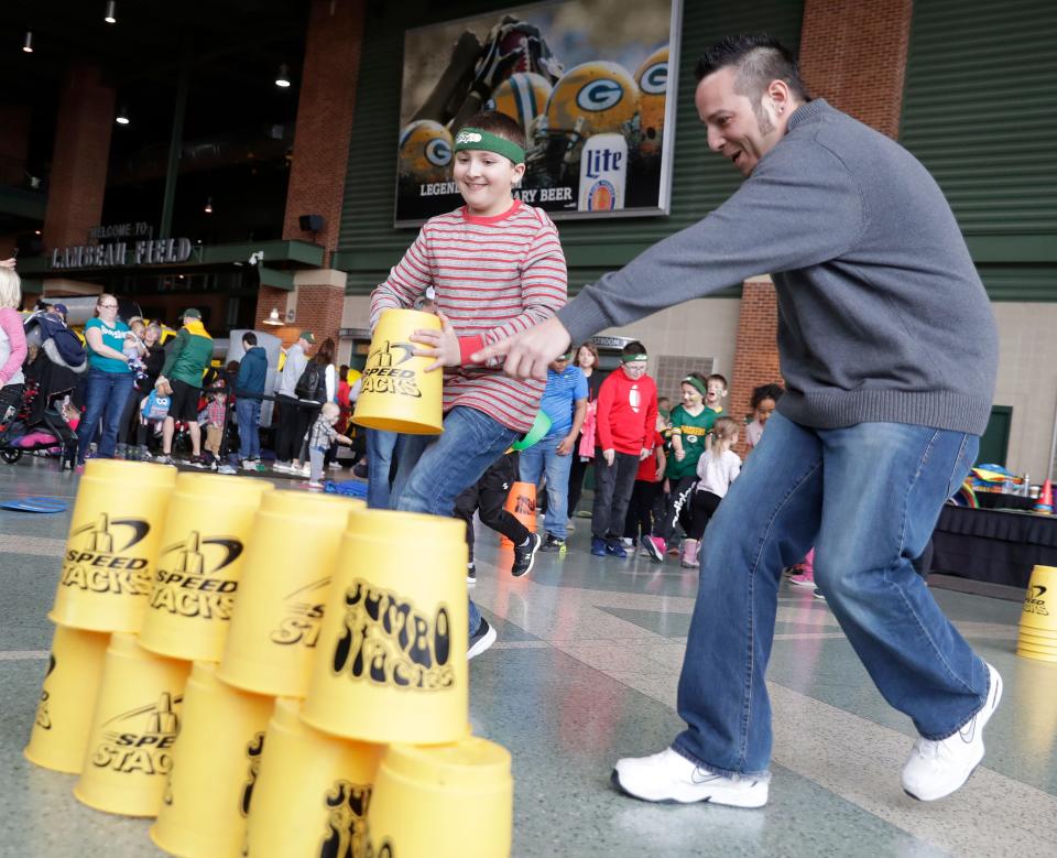 Kids participate in a cup-stacking team challenge during a past Project Play 60 at Lambeau Field. This year's free family event is on Feb. 17.