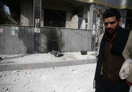 A man walks near missile remains in the besieged town of Douma, in eastern Ghouta, in Damascus, Syria, February 23, 2018. REUTERS/Bassam Khabieh