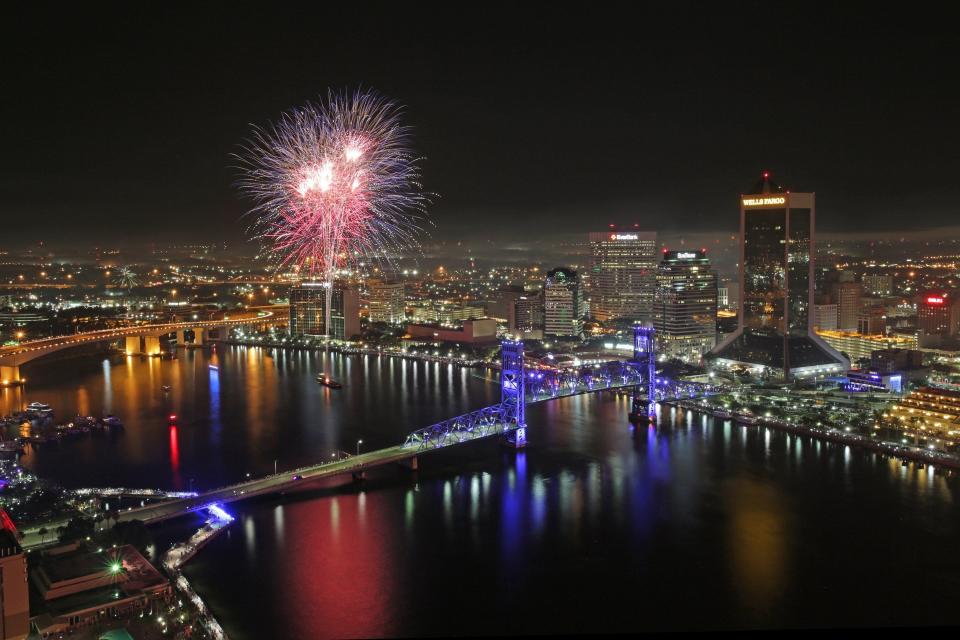 Fireworks go off over the St. Johns River at midnight.
