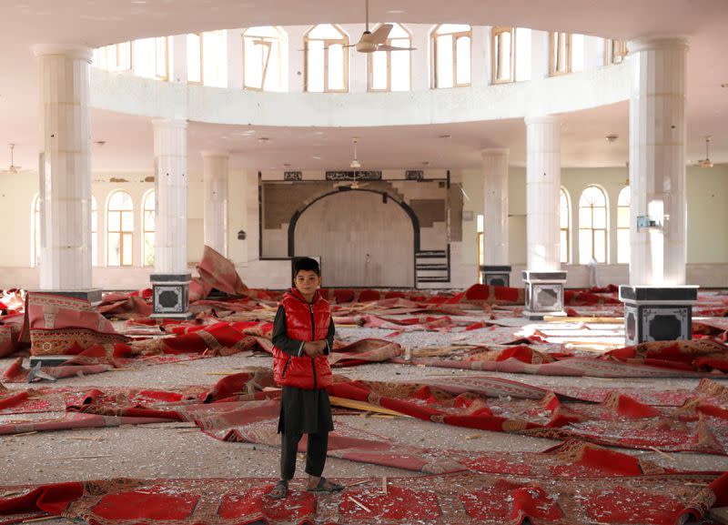 An Afghan boy stands inside a damaged mosque at the site of an attack in a U.S. military air base in Bagram