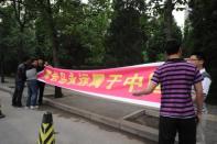 Plainclothes policemen try to stop two protesters holding a banner that says, "Huangyan island (Scarborough Shoal) will always belong to China" outside the Philippines embassy in Beijing, on May 11. China told its citizens they were not safe in the Philippines and its state media warned of war, as a month-long row over rival claims in the South China Sea threatened to spill out of control