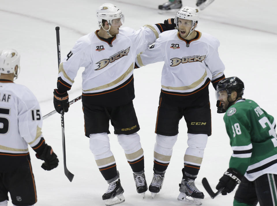 Anaheim Ducks center Nick Bonino (13) right celebrates scoring a goal with teammate Cam Fowler (4) during the third period of Game 6 of a first-round NHL hockey playoff series against the Dallas Stars in Dallas, Sunday, April 27, 2014. The Ducks won 5-4 in overtime. Looking on are Ducks Ryan Getzlaf (15) and Stars Vernon Fiddler (38). (AP Photo/LM Otero)