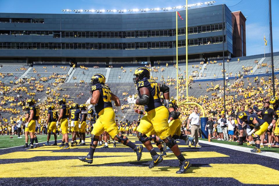 Michigan players, including offensive lineman LaDarius Henderson (73) warm up before the East Carolina game at Michigan Stadium in Ann Arbor on Saturday, Sept. 2, 2023.