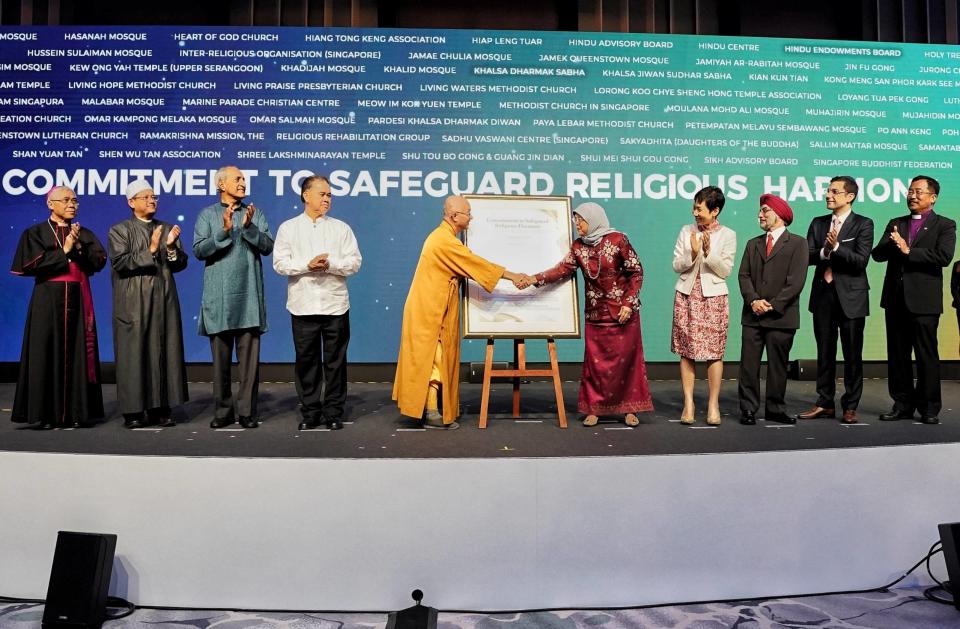 Senior religious leaders of Singapore present a framed copy of the commitment to safeguard religious harmony to President Halimah Yacob at the International Conference on Cohesive Societies at Raffles City Convention Centre on 19 June 2019. (PHOTO: International Conference on Cohesive Societies)