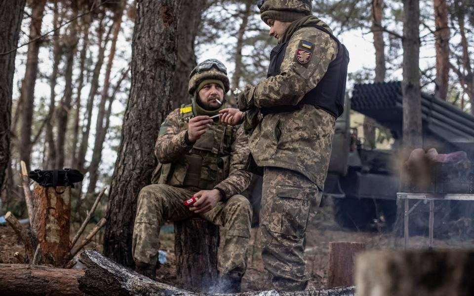 Ukrainian service members rest near their position at a frontline - Reuters