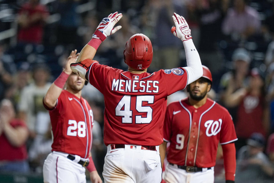 Washington Nationals designated hitter Joey Meneses celebrates his three-run home run with Lane Thomas (28) and Jeimer Candelario (9) during the eighth inning of the team's baseball game against the Colorado Rockies at Nationals Park, Tuesday, July 25, 2023, in Washington. The Nationals won 6-5. (AP Photo/Alex Brandon)