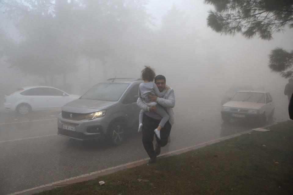 People are seen among the dust cloud formed after a building collapsed in the aftershock in Kahramanmaras.<span class="copyright">Kemal Ceylan—Anadolu Agency/Getty Images</span>