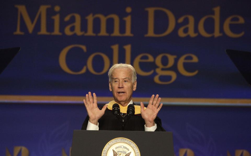 Vice President Joe Biden, center, speaks during a graduation ceremony at the Miami Dade College in Miami, Saturday, May 3, 2014. Biden said a "constant, substantial stream of immigrants" is important to the American economy, urging citizenship for immigrants living in the U.S. illegally. (AP Photo/Javier Galeano)