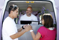 LAS VEGAS - OCTOBER 6: The Rev. Andy Gonzalez (C) officiates a wedding vows renewal ceremony between Jay Junio (L) and Anne Junio of California at the Las Vegas Wedding Wagon in the parking lot of the Welcome to Fabulous Las Vegas sign on October 6, 2012 in Las Vegas, Nevada. For USD 99, ordained ministers will drive a van with an altar to any location in and around Las Vegas and perform a legal wedding, vow renewal or commitment ceremony in about 10 minutes. The fee includes wedding photos but not a marriage license. Couples can either get hitched at the Wedding Wagon's walk-up window or at iconic areas including the Welcome to Fabulous Las Vegas sign, the fountains at the Bellagio, the Hoover Dam and pedestrian bridges overlooking the Las Vegas Strip. (Photo by Isaac Brekken/Getty Images)