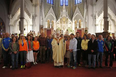 Boston Cardinal Sean O'Malley (C) poses with 2014 Boston Marathon runners and workers after blessing them at the front of the Cathedral of the Holy Cross during Easter Mass in Boston, Massachusetts April 20, 2014. REUTERS/Brian Snyder