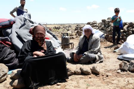 FILE PHOTO: Internally displaced from Deraa province sit next to belongings near the Israeli-occupied Golan Heights, in Quneitra, Syria June 21, 2018. REUTERS/Alaa al-Faqir