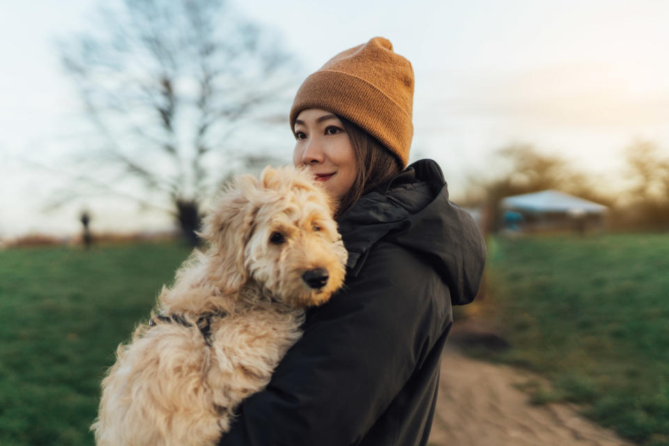 A woman holding a dog outside