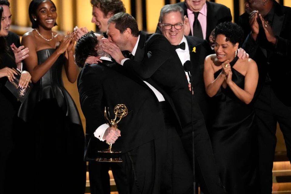 Matty Matheson, centre, and Ebon Moss-Bachrach kiss as The Bear wins the award for outstanding comedy series during the 75th Primetime Emmy Awards on Monday, Jan. 15, 2024, at the Peacock Theater in Los Angeles. 
