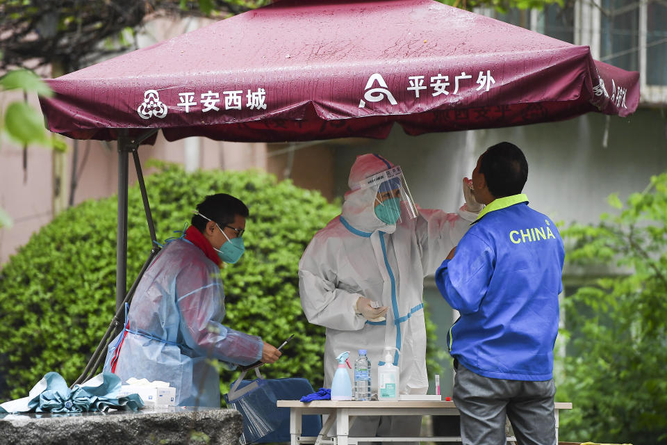 BEIJING, CHINA - APRIL 27: Medical workers wearing protective suits take swab samples from residents for nucleic acid testing at a community in Chaoyang District on April 27, 2022 in Beijing, China. China is trying to contain a spike in coronavirus cases in the capital Beijing after dozens of people tested positive for the virus in recent days, causing local authorities to initiate mass testing in most districts and to place some neighbourhoods under lockdown where cases are found in an effort to prevent the spread of COVID-19. (Photo by Lintao Zhang/Getty Images)