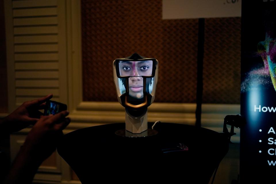 A person takes a picture of a Wehead interactive AI interface at the Wehead booth at Pepcom ahead of the CES tech show Monday, Jan. 8, 2024, in Las Vegas. The device allows for human to AI interaction.