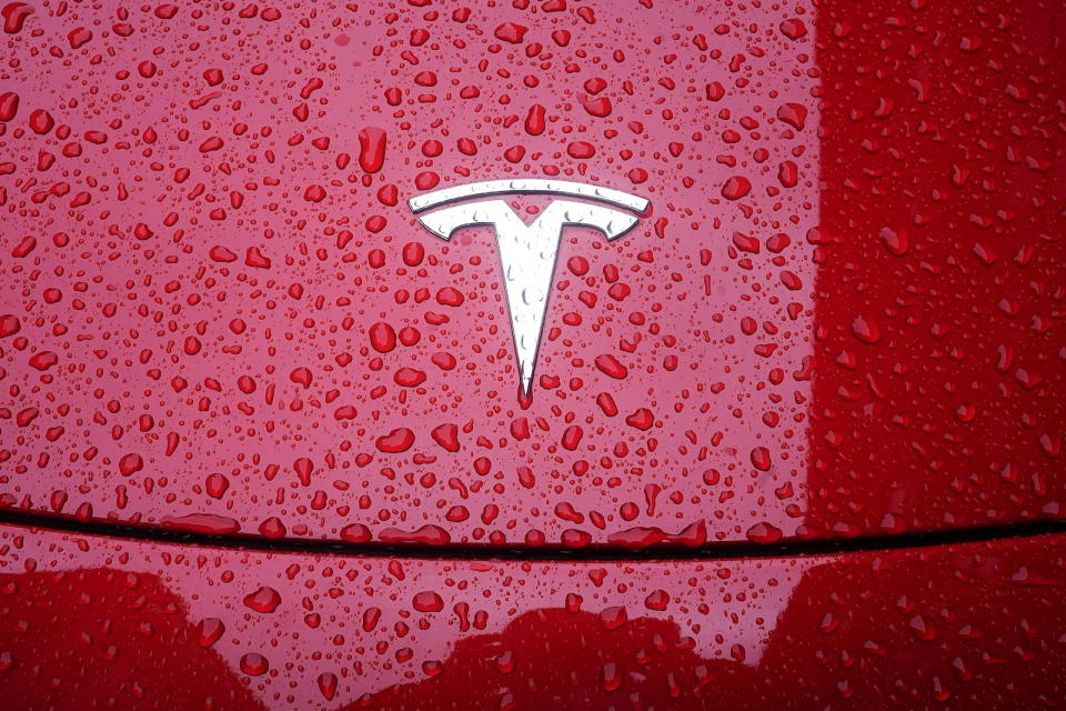 A Tesla logo is pictured on a car in the rain in the Manhattan borough of New York City, New York, U.S., May 5, 2021. REUTERS/Carlo Allegri - RC2R9N957EOE