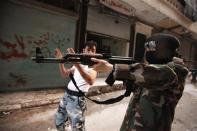 A female member of the "Mother Aisha" battalion receives instruction as she holds a rifle during military training in Aleppo's Salaheddine district, September 19, 2013. REUTERS/Loubna Mrie