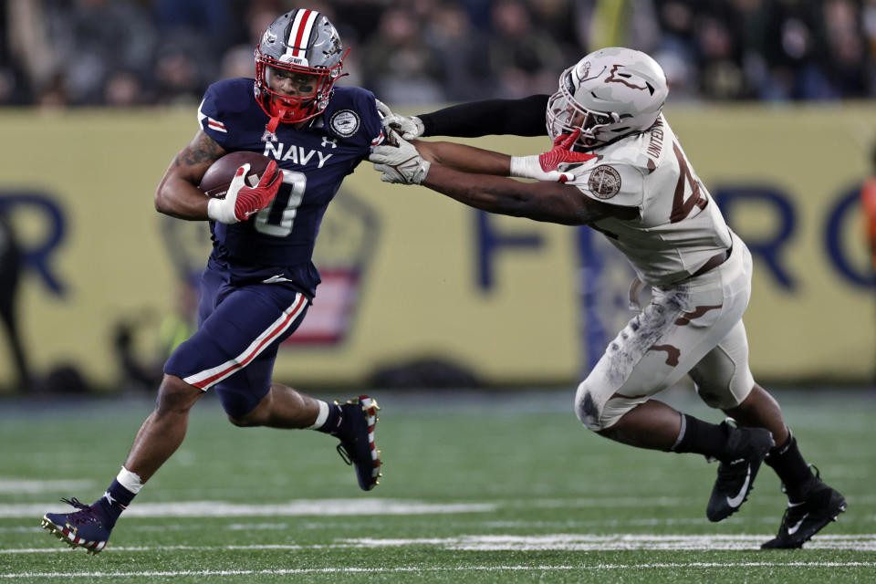 FILE - Navy fullback Chance Warren (0) runs against Army during the second half of an NCAA college football game Dec. 11, 2021, in East Rutherford, N.J. Army and Navy will line up their triple-option offenses on Saturday, Dec. 9, 2023, at the home of the New England Patriots for a day full of pageantry, tradition and a deeply rooted respect that comes with one of college football's fiercest rivalries. (AP Photo/Adam Hunger, File)